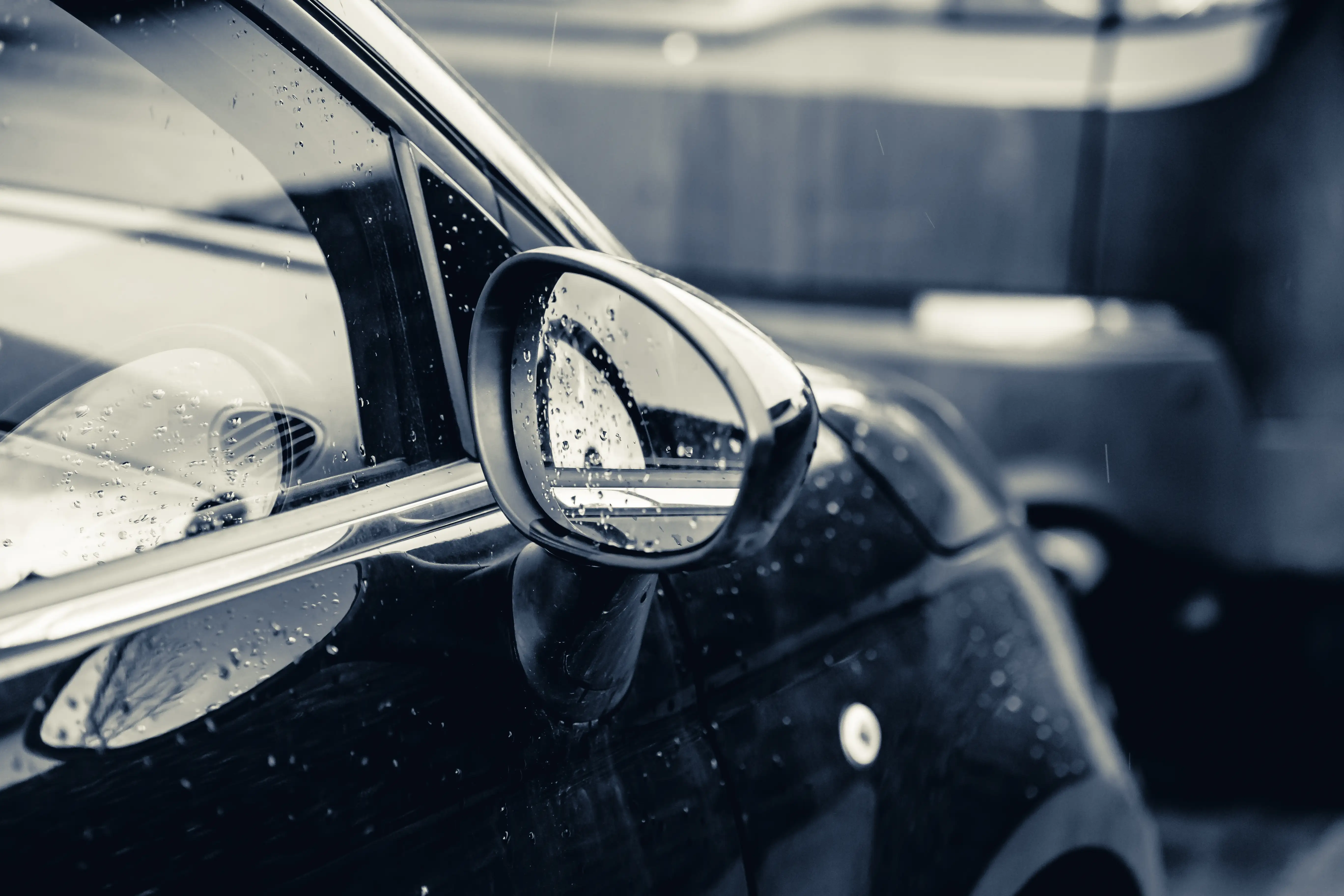 closeup rearview mirror black car covered raindrops closeup rearview mirror black car covered raindrops